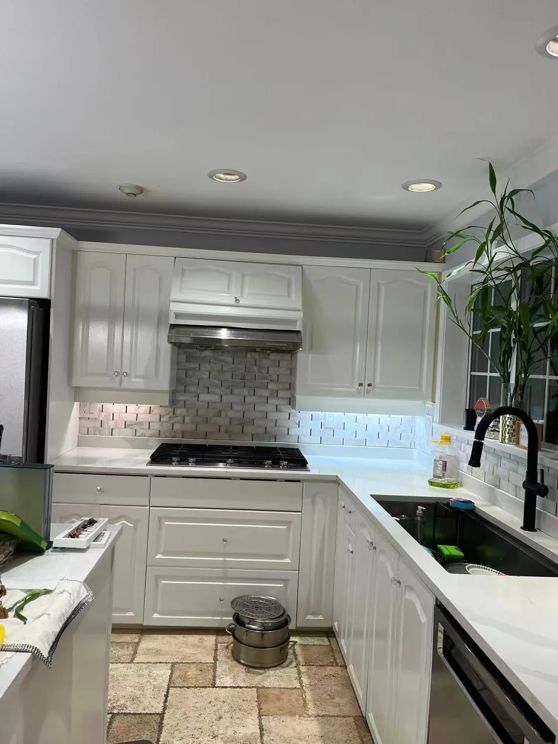 A kitchen in the style of a house thirty to forty years old, with the original wood-tone cabinets making the room look dated. The owner was preparing to sell and wanted the white finish buyers expect today.