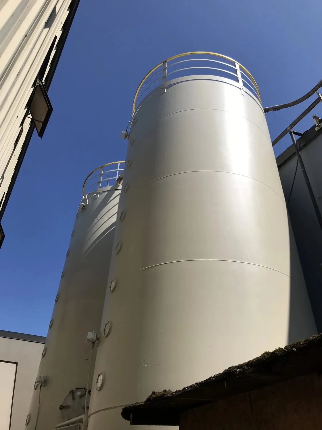 A food-processing plant in Delta runs two exterior silos that hold flour. After years in service the steel had gone to rust. Mayda ground the rust back to bare metal, primed with an oil-based rust inhibitor and laid the top coat on by roller.